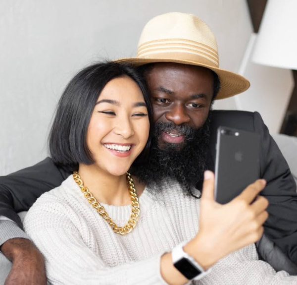 Photo of couple using Mobile Phone for selfie.